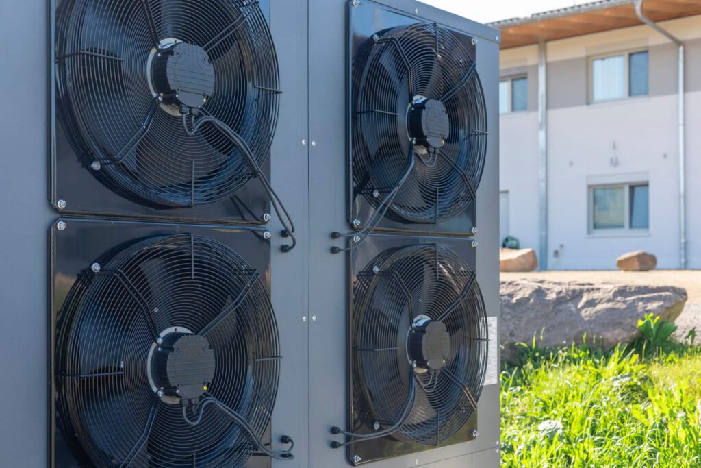 Commercial outdoor air conditioning condenser units installed beside a building.